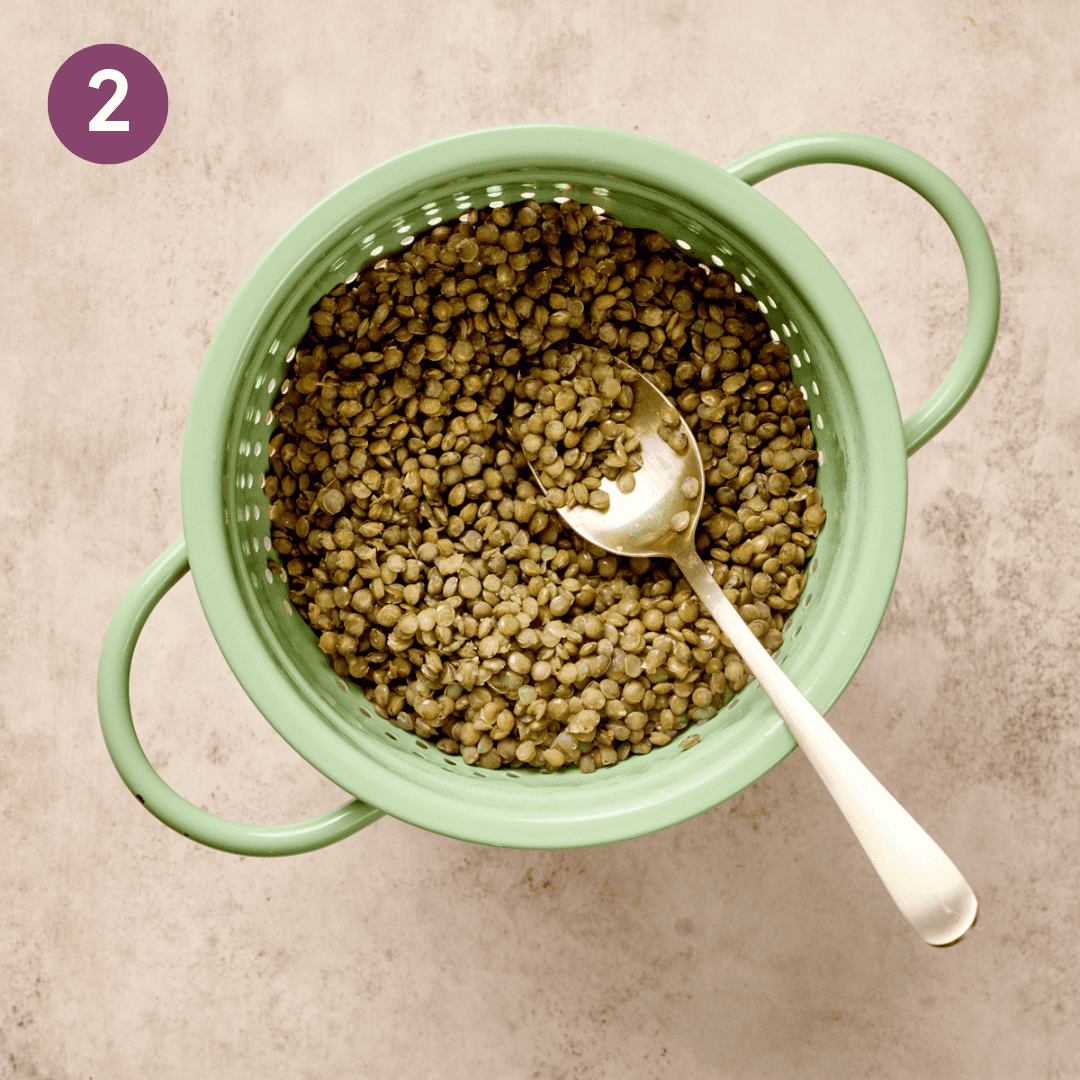 Lentils and a spoon in a colander.