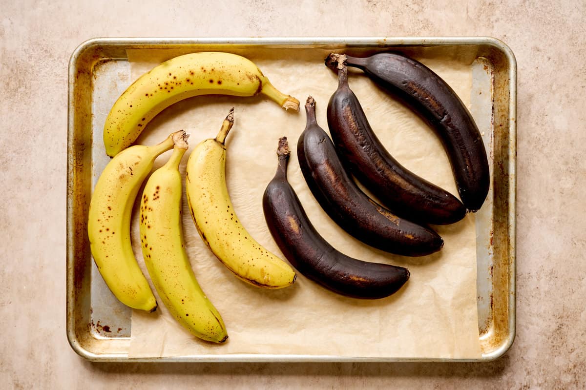 Ripe and overripe bananas on a baking sheet.