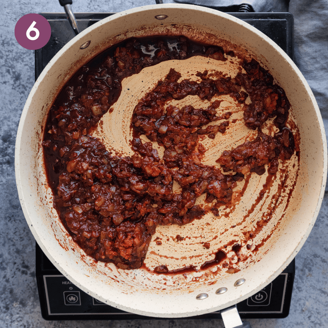 Wine and tomato onion mixture in pan.