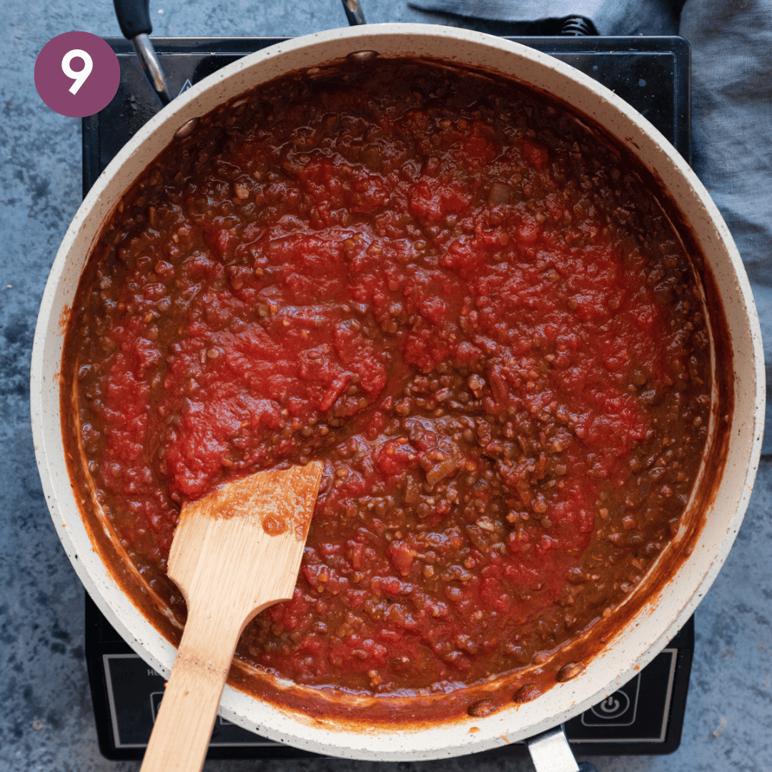 Tomatoes added to lentil walnut mixture in the pan.