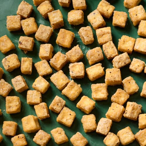 close up of baked tofu on a baking sheet.