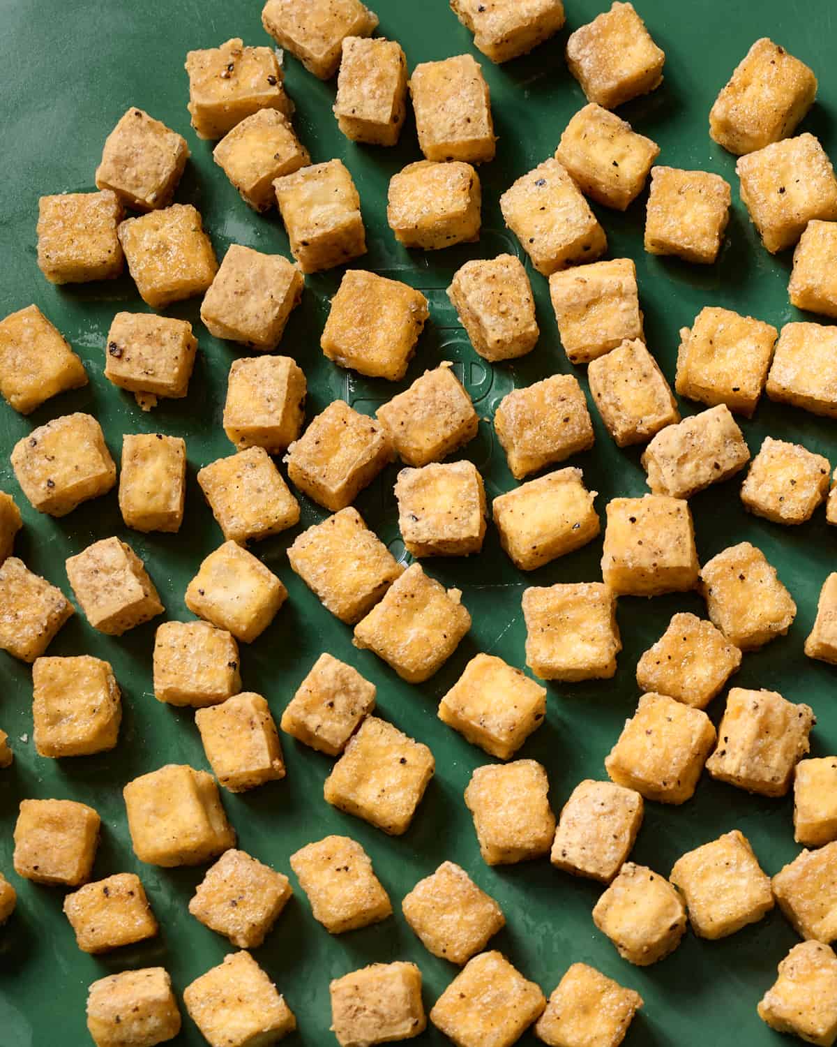 close up of baked tofu on a baking sheet.