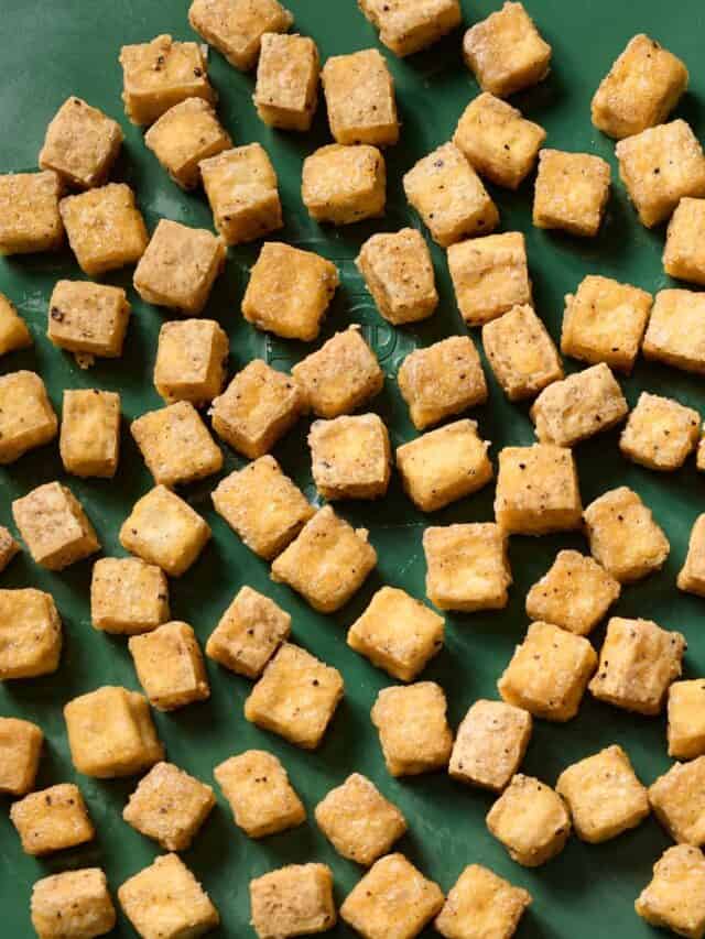 close up of baked tofu on a baking sheet.