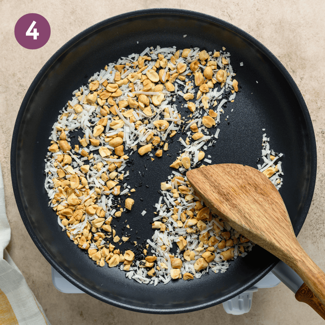 Sesame seeds, coconut, and peanuts toasting in a pan.