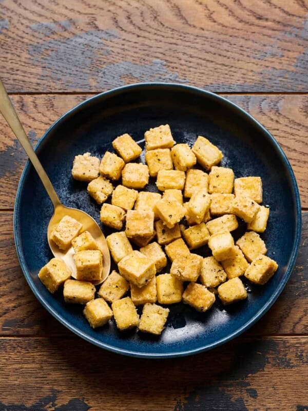 Fried tofu in a bowl on a wooden table.