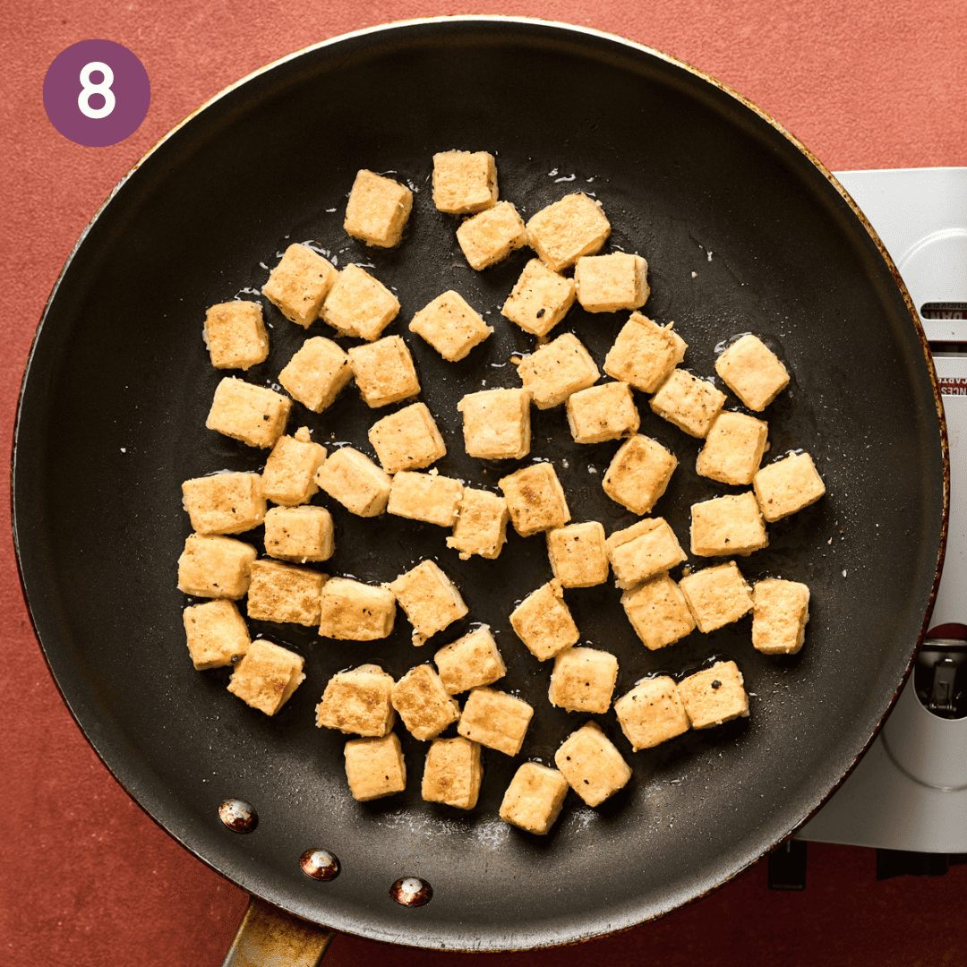 Finished fried tofu cubes in a skillet.
