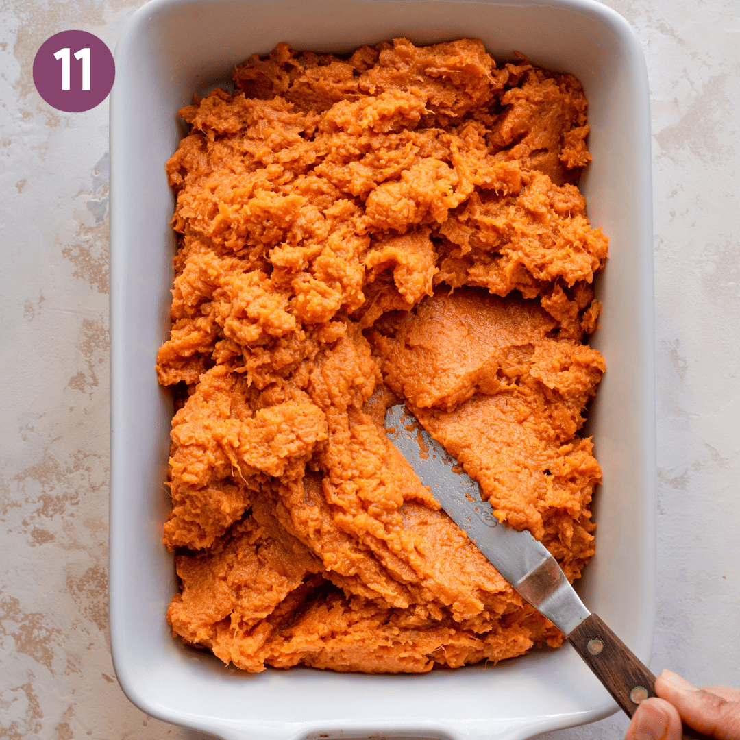 Sweet potato mash in a ceramic dish before being smoothed out.