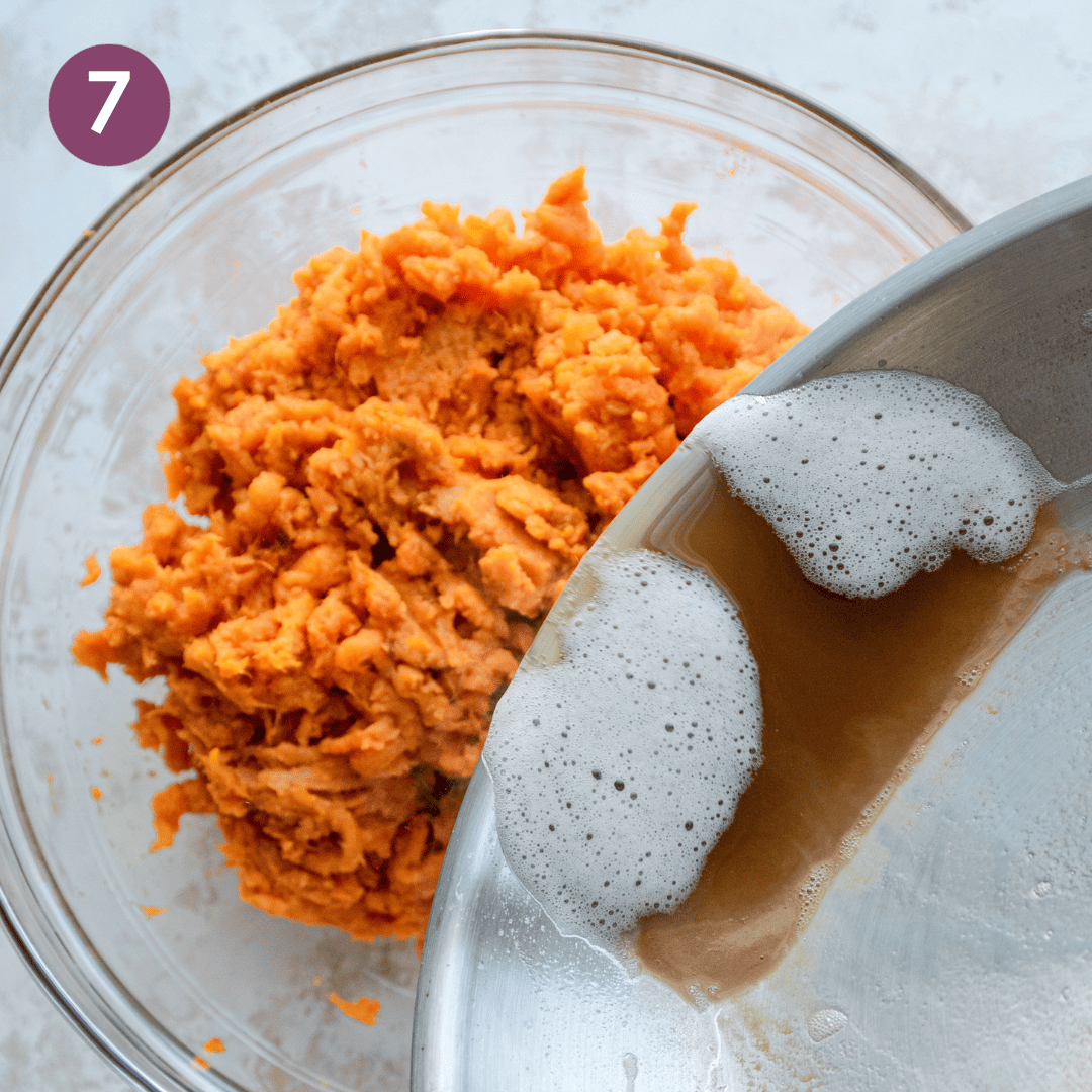 Person pouring browned butter into the mashed sweet potatoes.