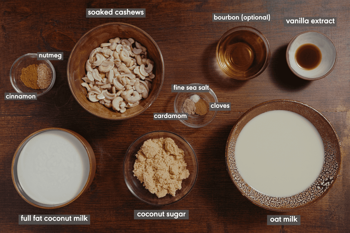 vegan eggnog ingredients in various bowls on a brown table.