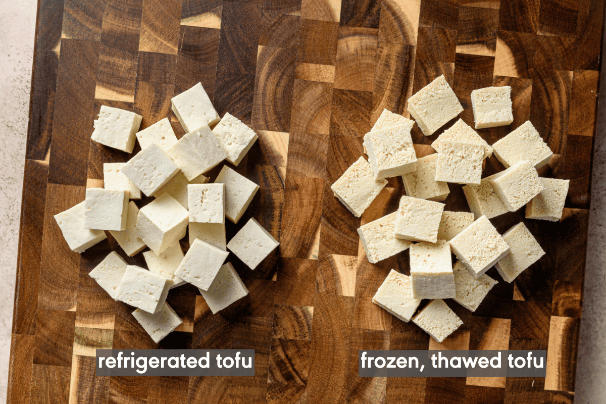 refrigerated tofu cubes and frozen, thawed tofu cubes on a wooden cutting board.