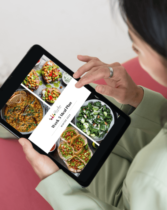woman gazing at a Rainbow Plant Life meal plan on her ipad.