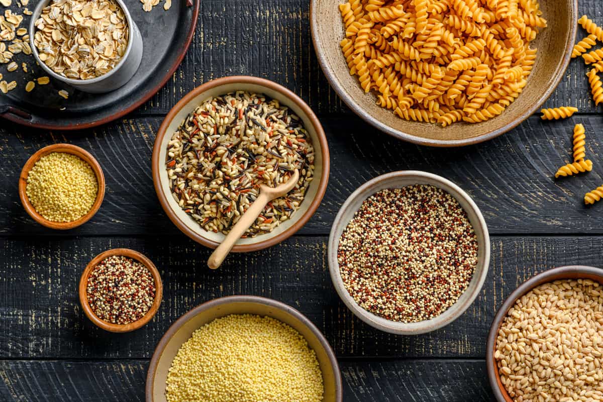 various types of grains arranged in different bowls on a table.