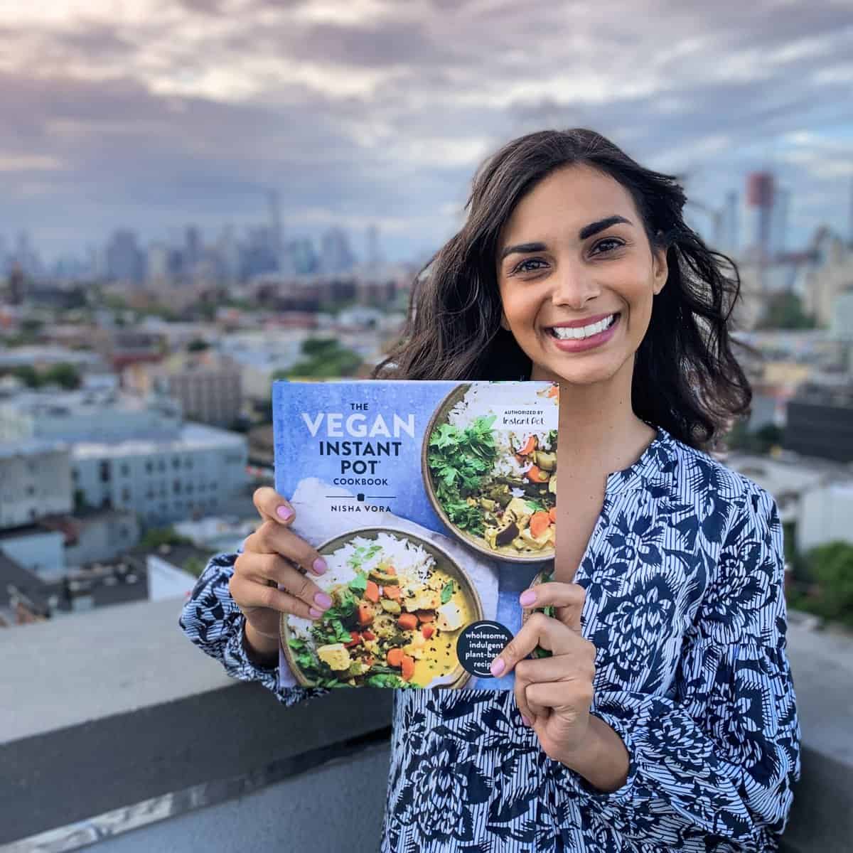 Nisha holding her instant pot cookbook in nyc