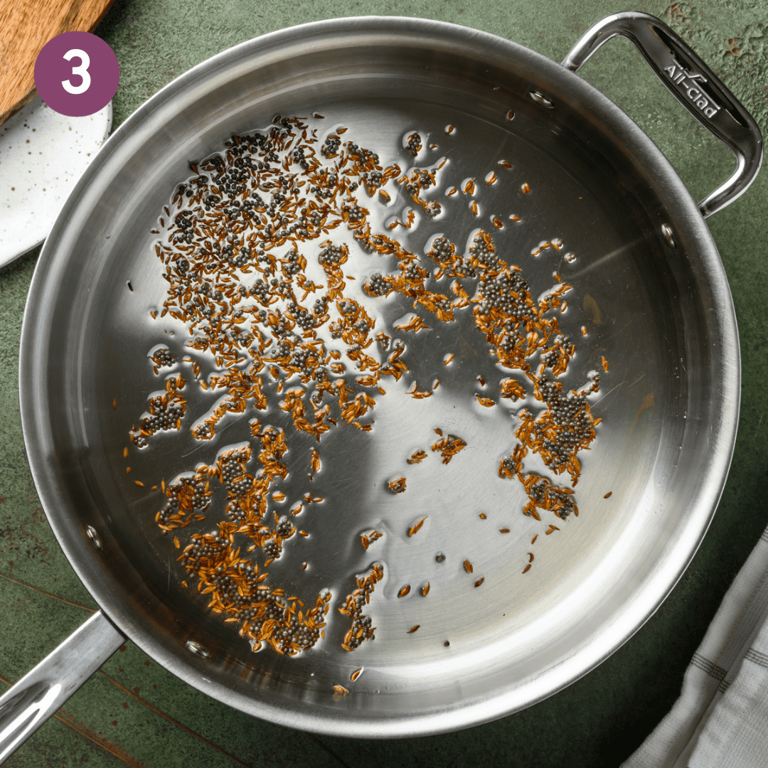 cumin and mustard seeds shimmering in oil in a deep saucepan.