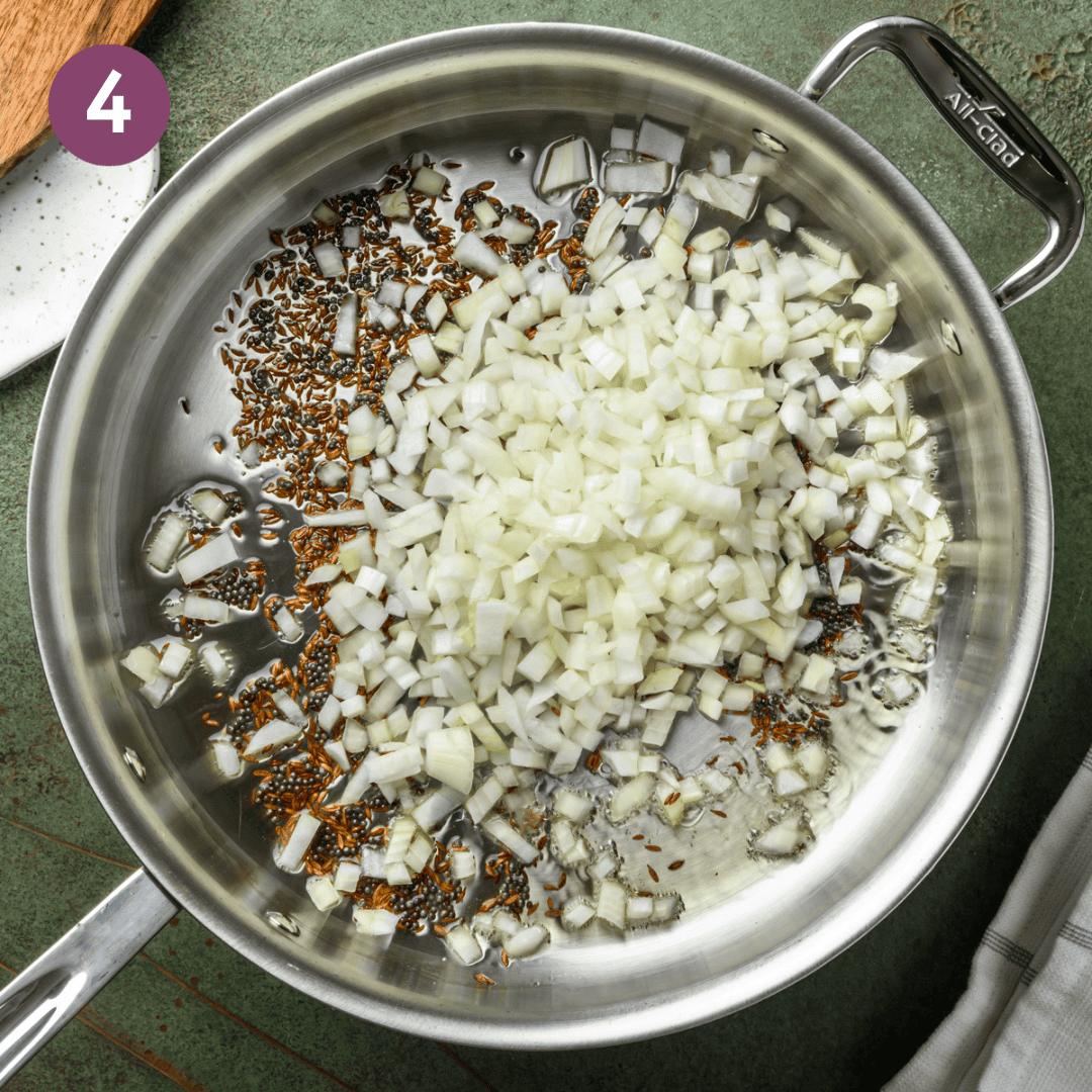 onion added to cumin and mustard seeds in the saucepan.