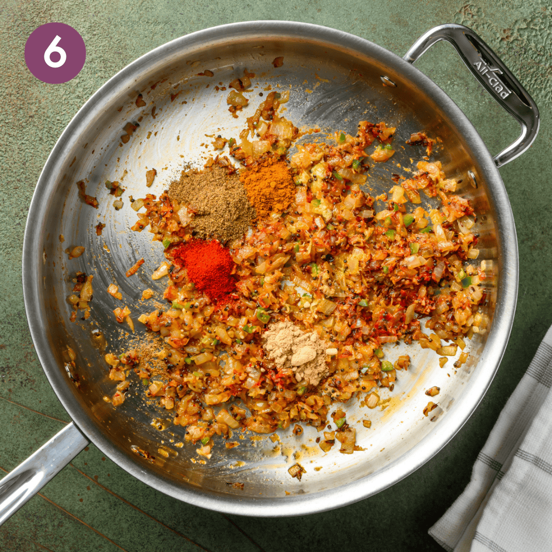 ground spices added to aromatic and tomato paste mixture.