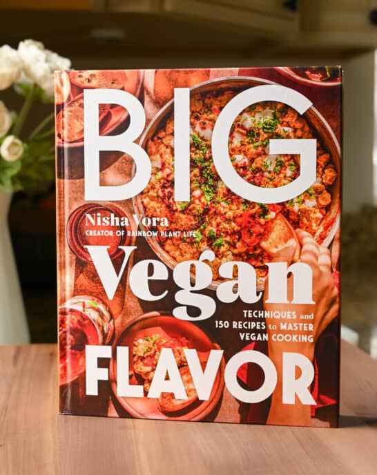 The Big Vegan Flavor cookbook resting on a cutting board.