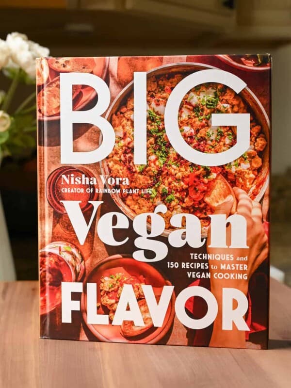 The Big Vegan Flavor cookbook resting on a cutting board.