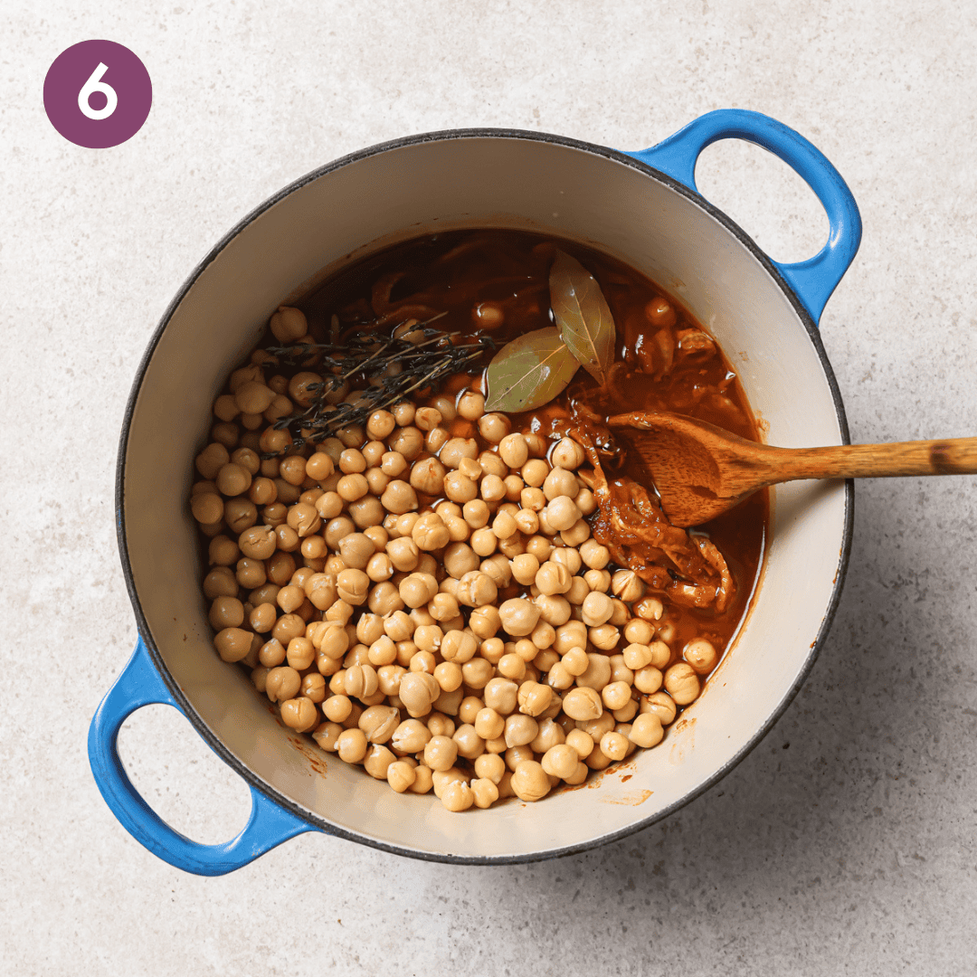 chickpeas, olive oil, vegetable broth, thyme sprigs, bay leaves, salt and pepper added to the pot.