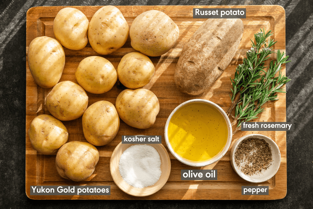 ingredients for making crispy roasted potatoes on a wooden cutting board.