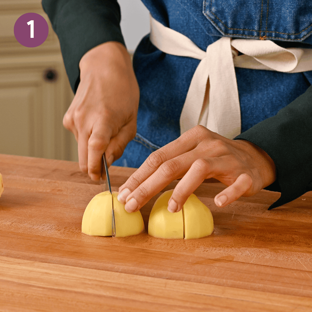 person cutting potatoes into quarters.