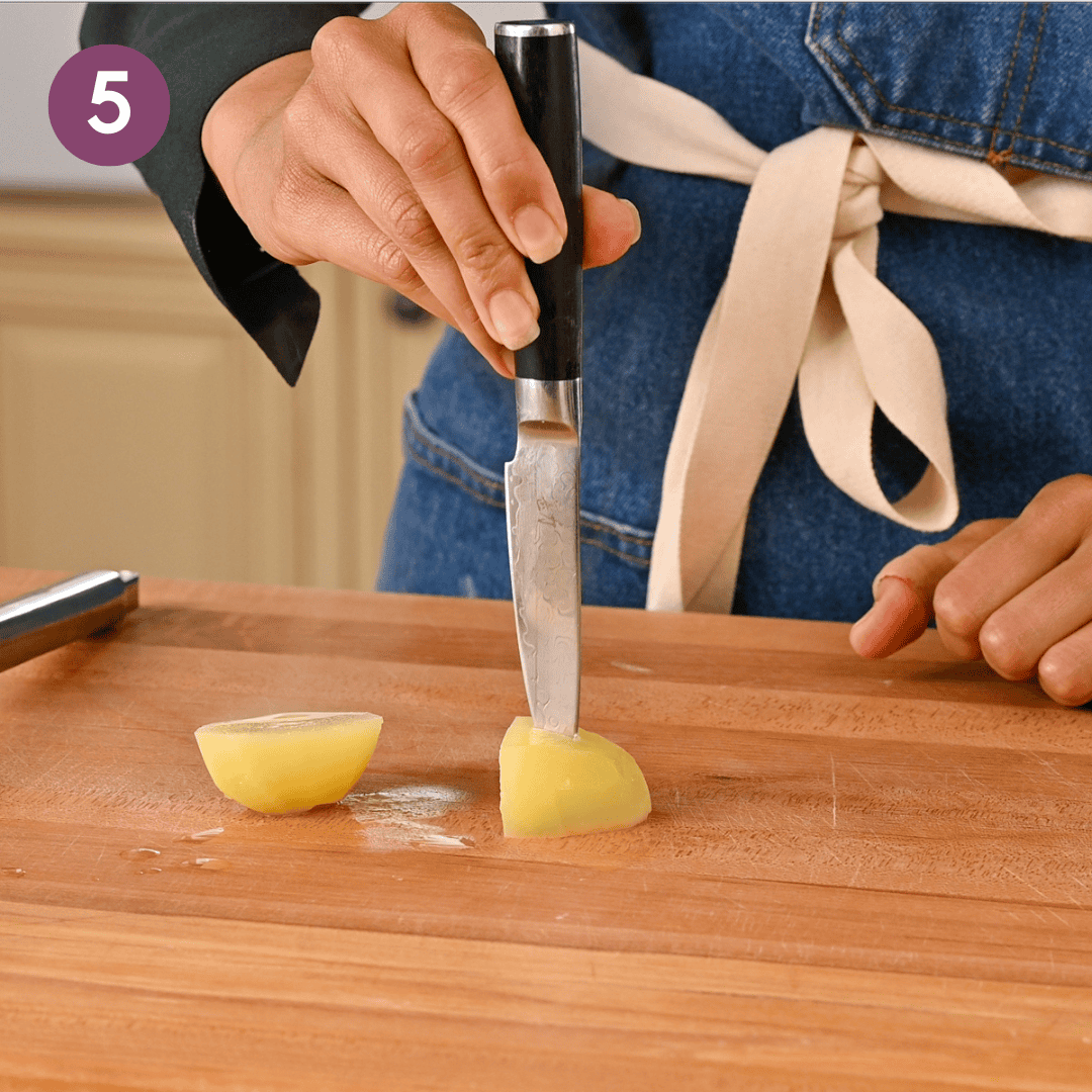 person using a pairing knife to test the resistance of the cooked potato.