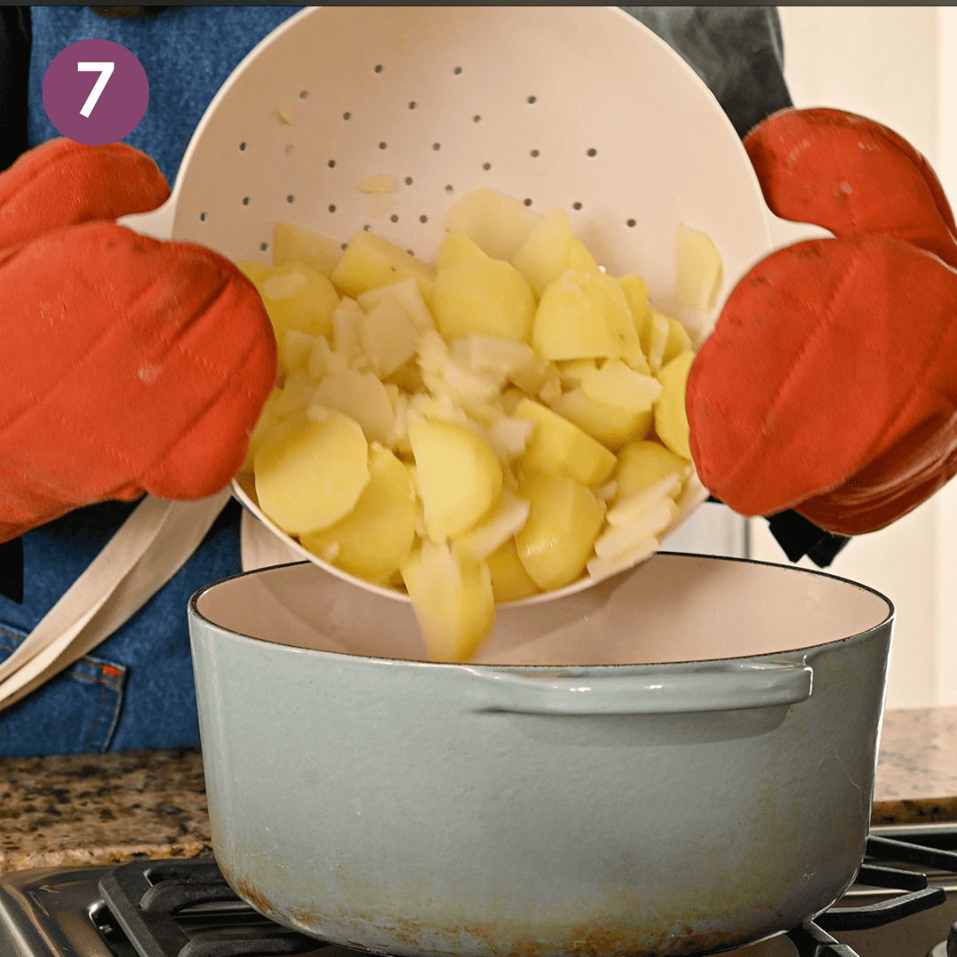 person returning parboiled potatoes to hot pan to dry out a bit.