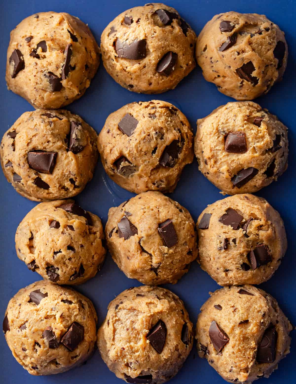 twelve unbaked cookie rounds next to each other on baking tray.