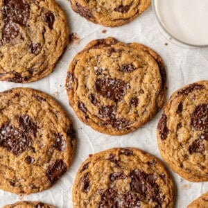 several big vegan chocolate chip cookies on parchment paper.