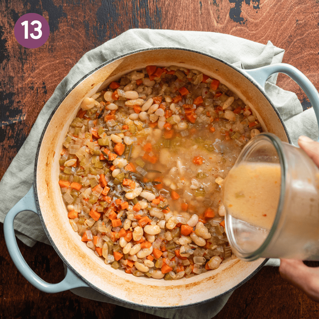 pouring miso broth from a jar into a pot of white bean soup. 