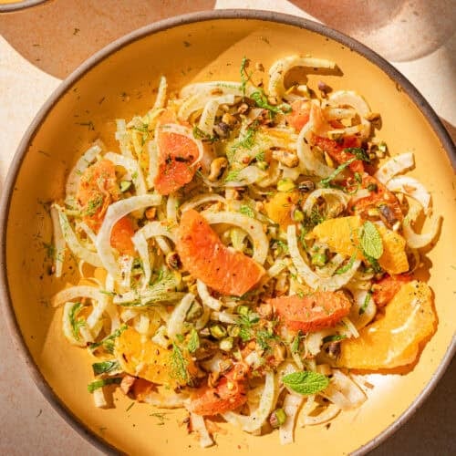 fennel orange salad in a yellow bowl with direct light.