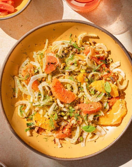 fennel orange salad in a yellow bowl with direct light.