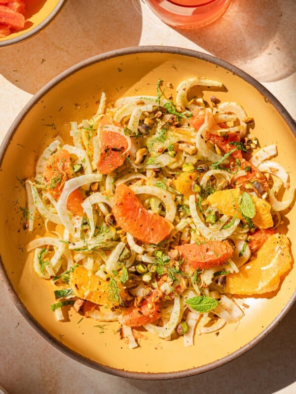 fennel orange salad in a yellow bowl with direct light.