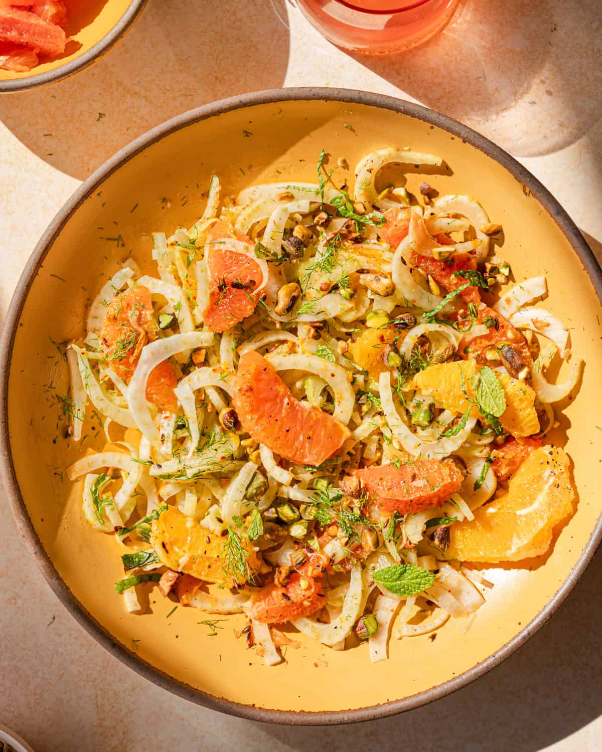 fennel orange salad in a yellow bowl with direct light. 