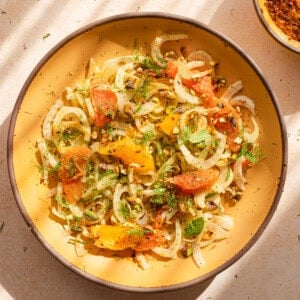 fennel orange salad in a yellow bowl with dappled light.