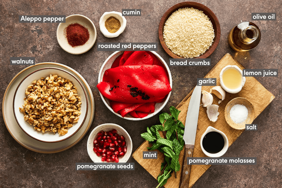 Ingredients for muhammara in various bowls on a table.