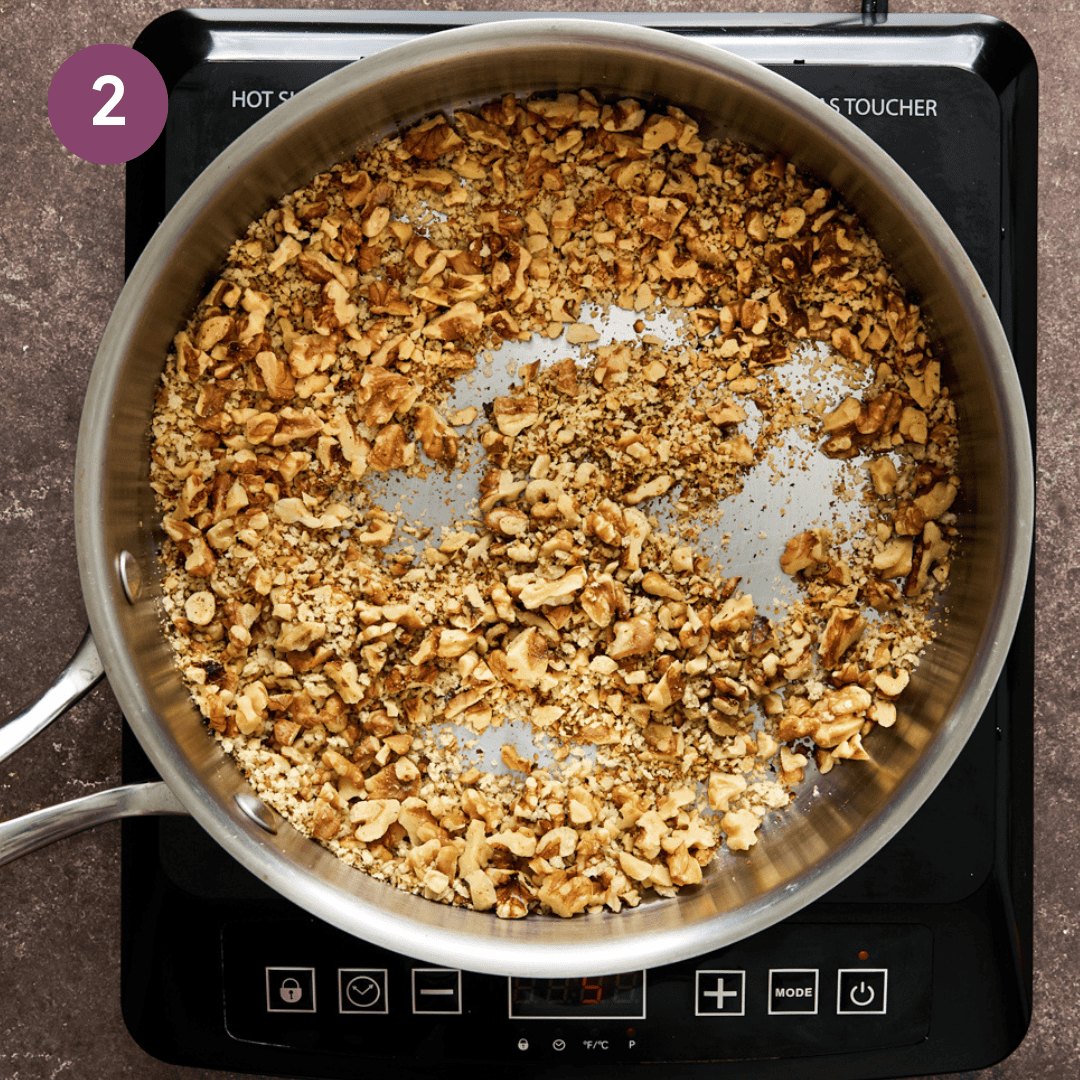 walnuts and bread crumbs being sauteed in a frying pan.