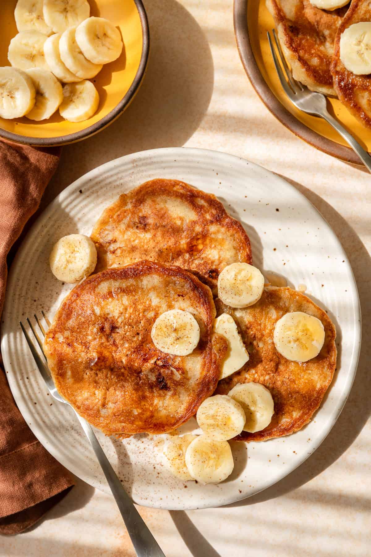 Overhead photo of 3 banana pancakes on a plate.