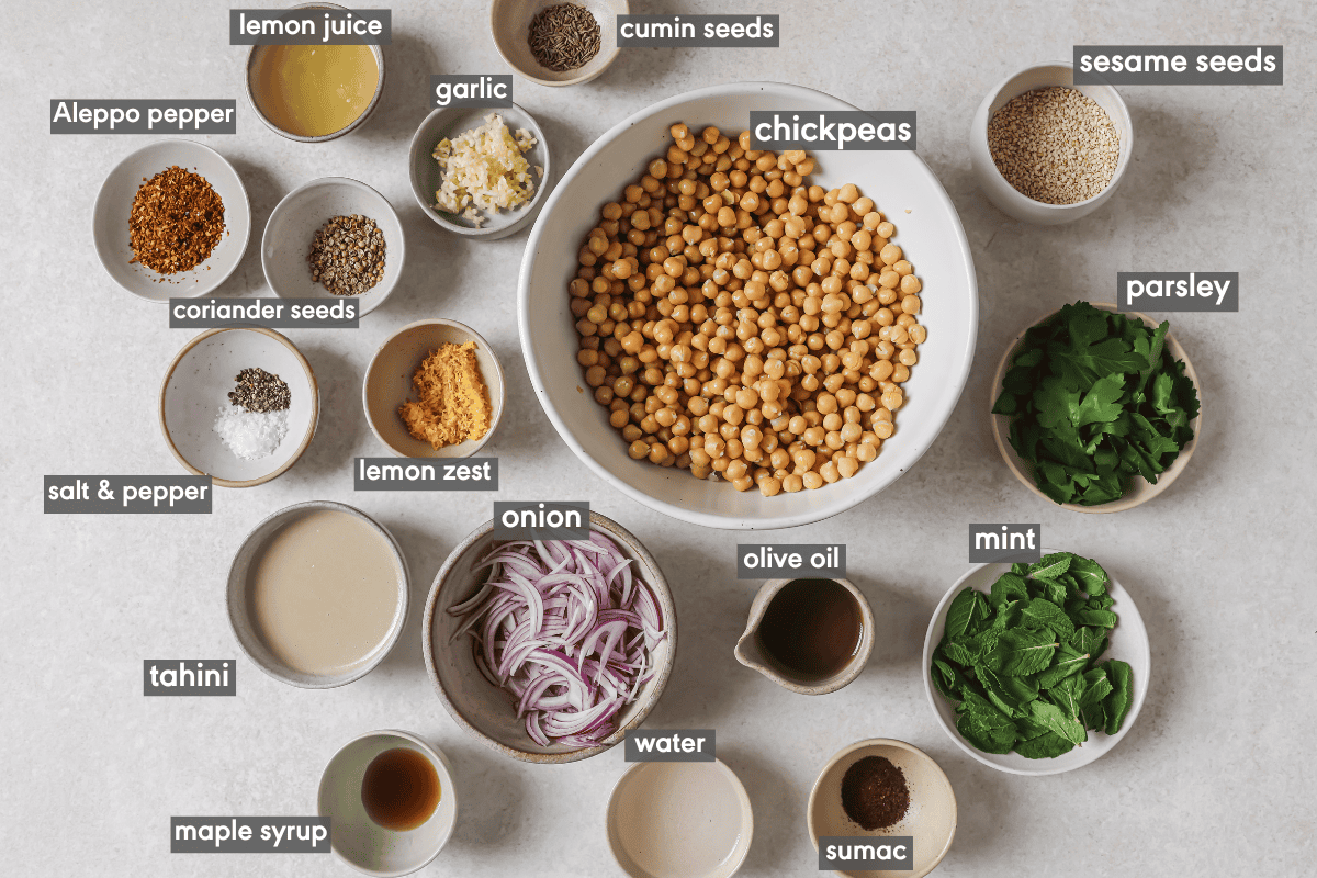 ingredients for mediterranean chickpea salad in various bowls on a table.