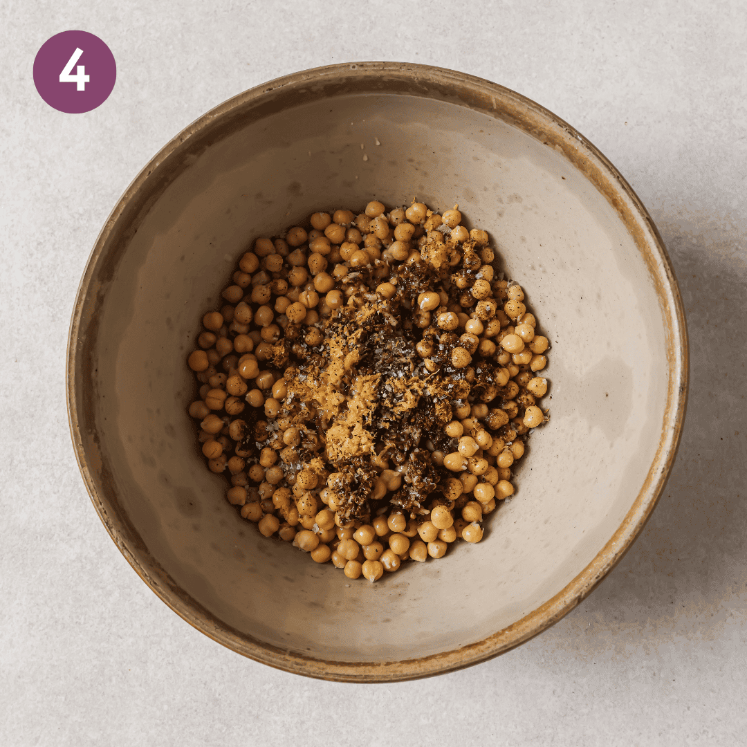 spiced garlic oil, chickpeas, lemon juice and zest and sumac in a bowl.