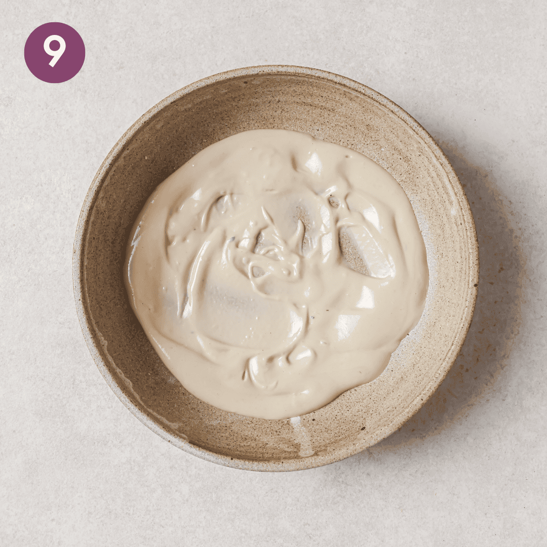 tahini dressing on a thin layer of a shallow bowl.
