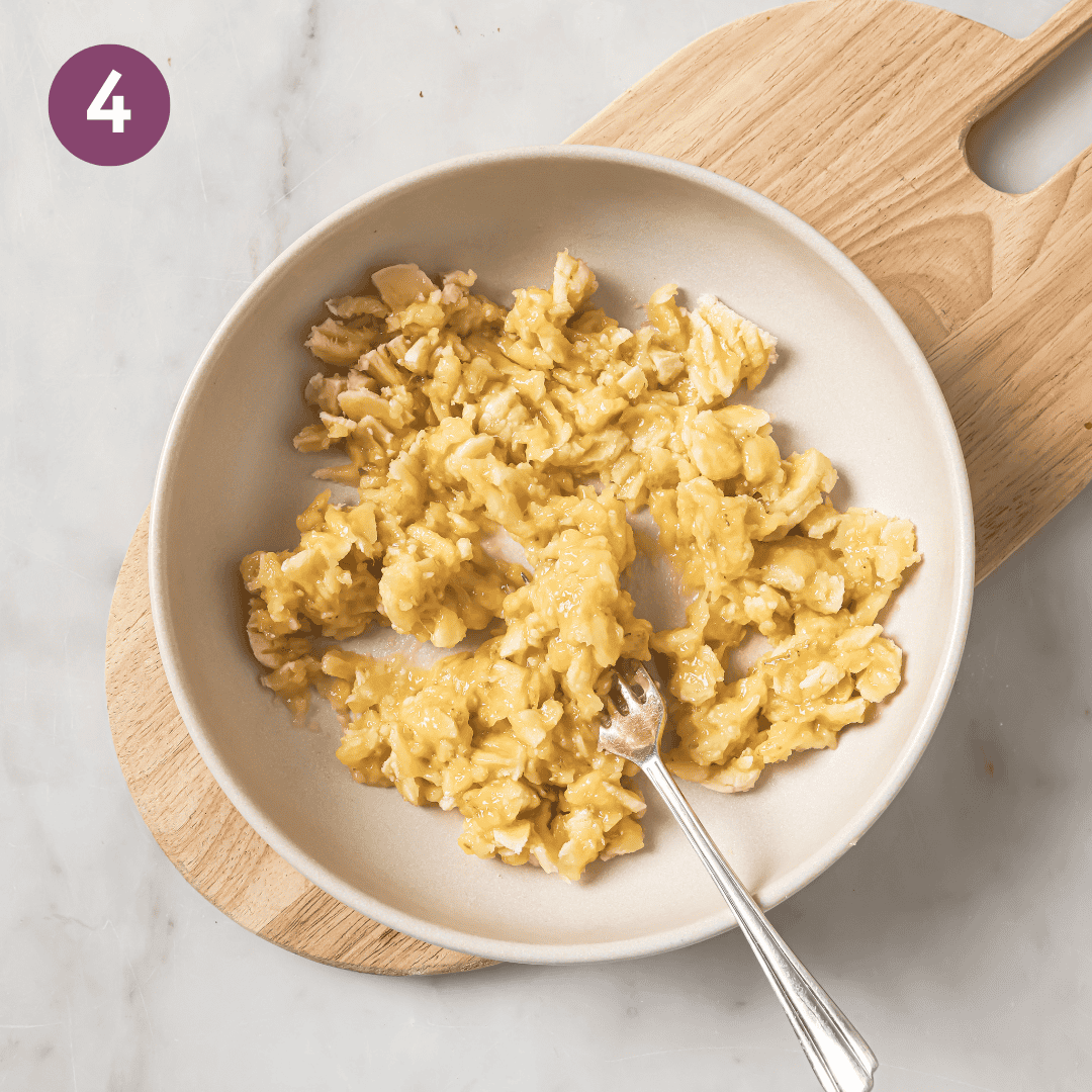 Fork and mashed bananas in a medium bowl.