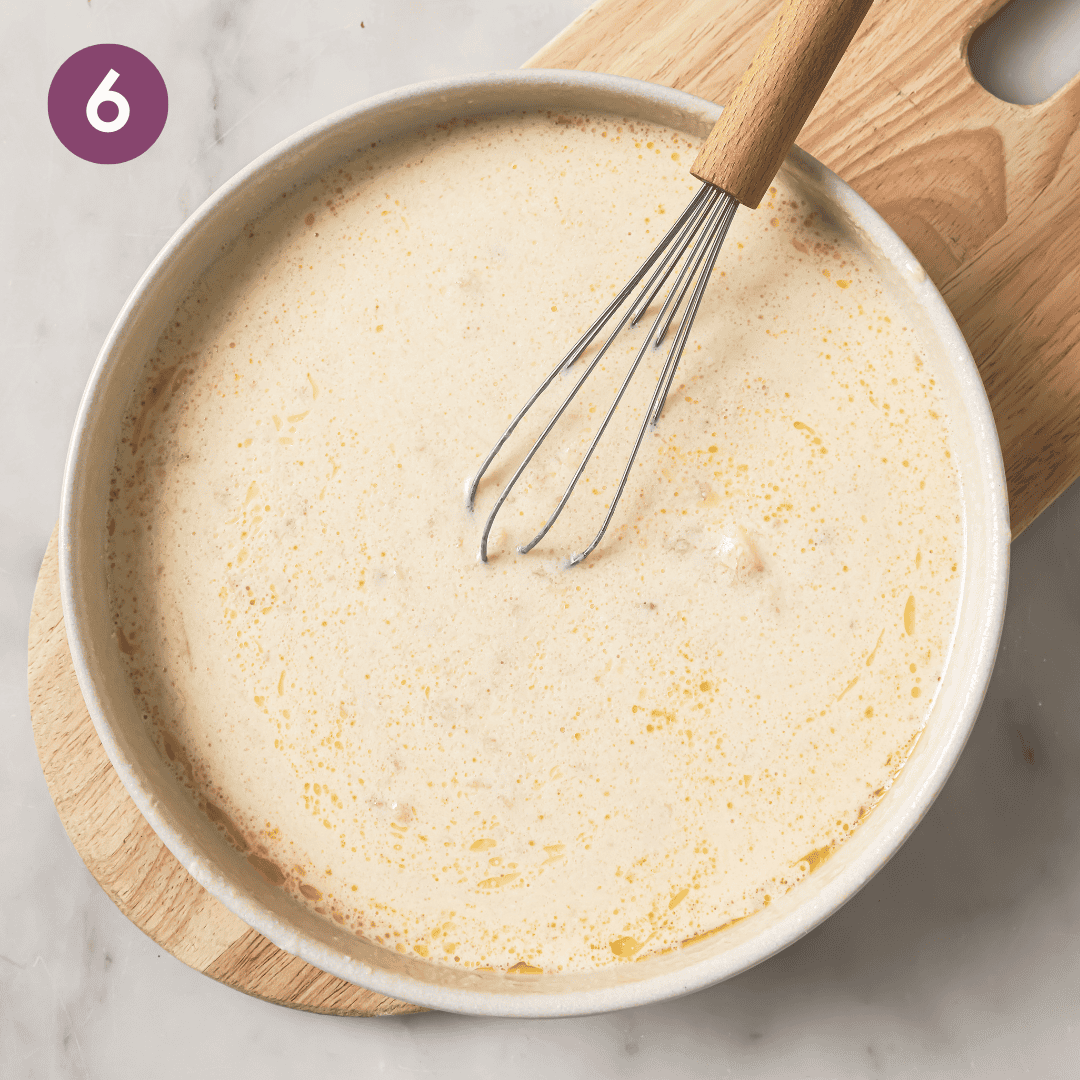 Person whisking together bananas and liquid ingredients.