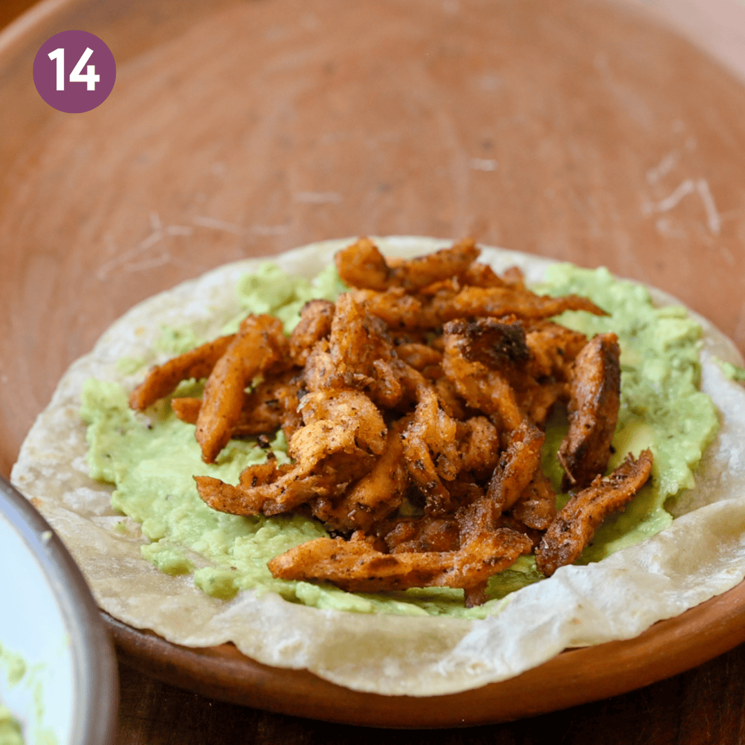 tortilla smeared with guacamole and topped with the soy curls on a plate.