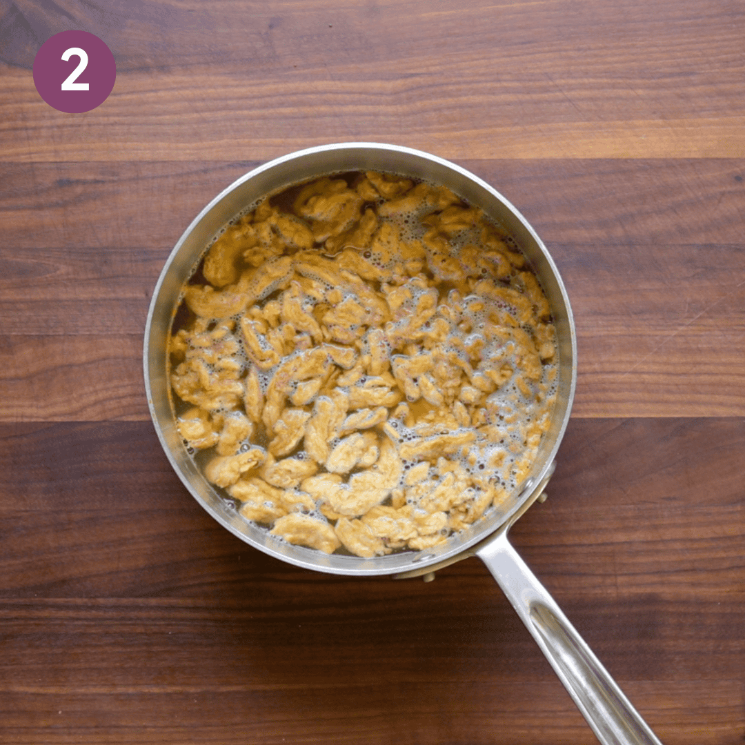 soy curls submerged in the hot broth in the saucepan.