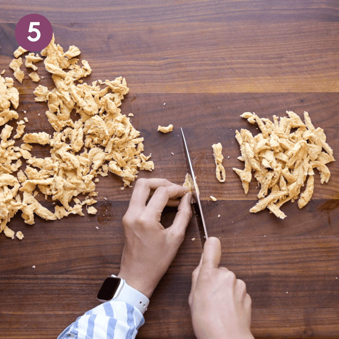 Person cutting soy curls into smaller pieces.