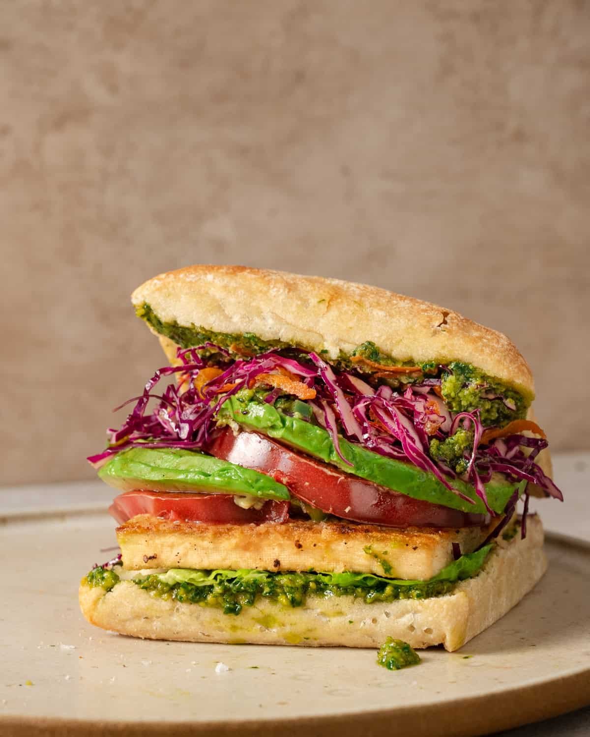 side view of crispy tofu sandwich on a plate.
