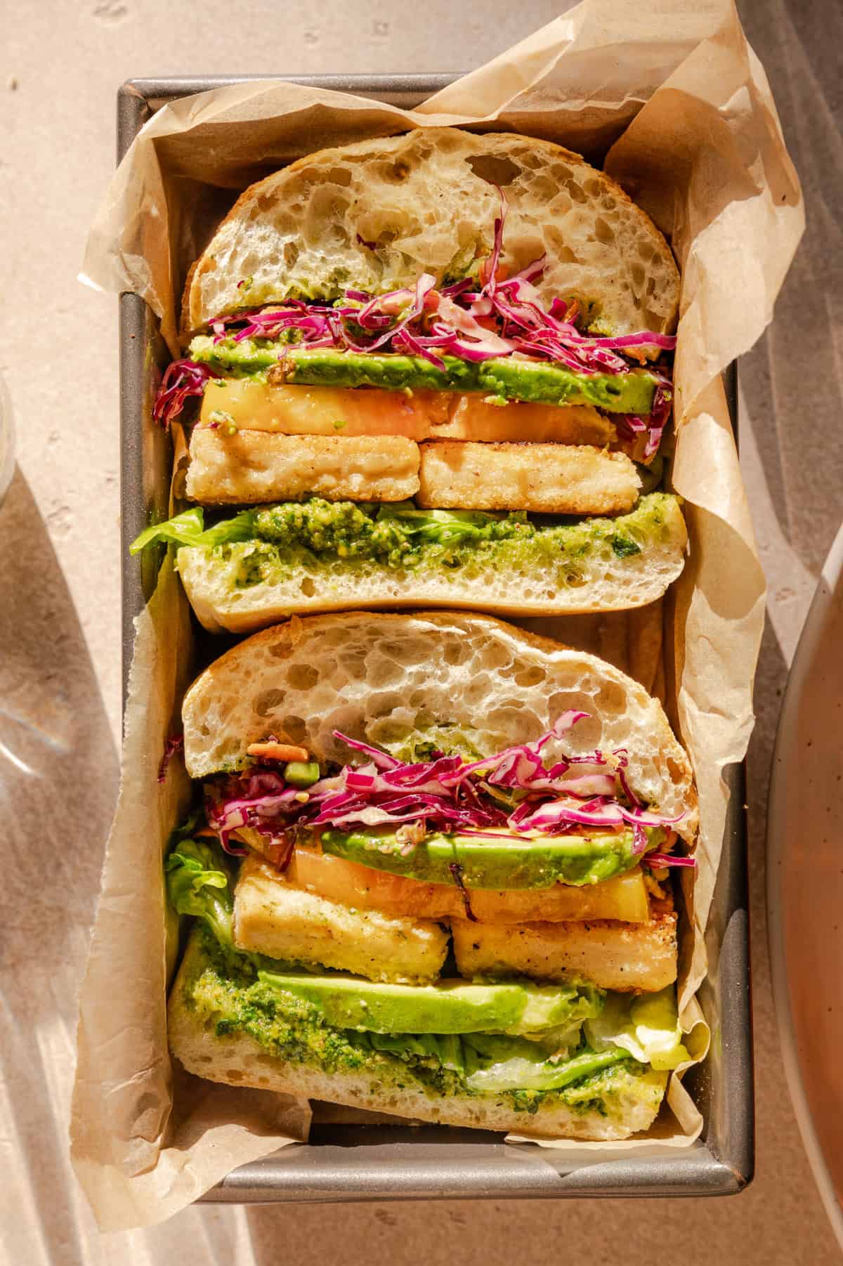 overhead view of two halved sandwiches in a box.