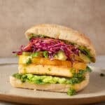 side view of crispy tofu sandwich on a plate.