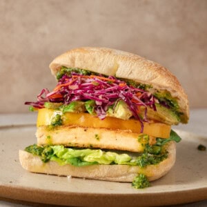 side view of crispy tofu sandwich on a plate.